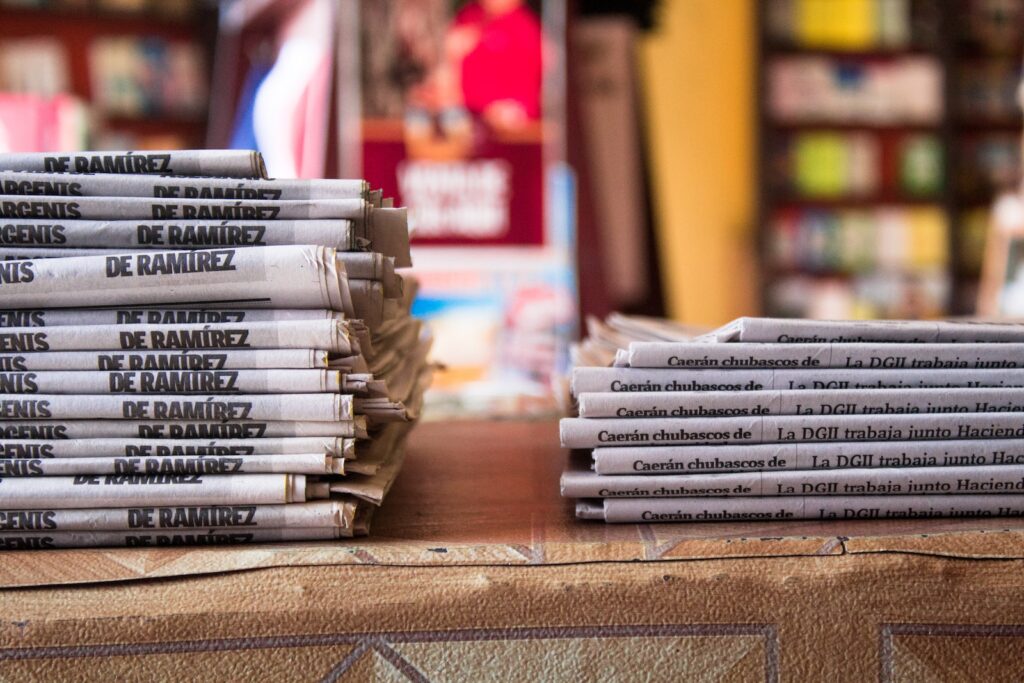a stack of newspapers sitting on top of a table